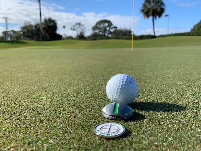 A titleist golf ball in front of an On Point Ball Marker used in a product review by Michael Duranko of GolfToons